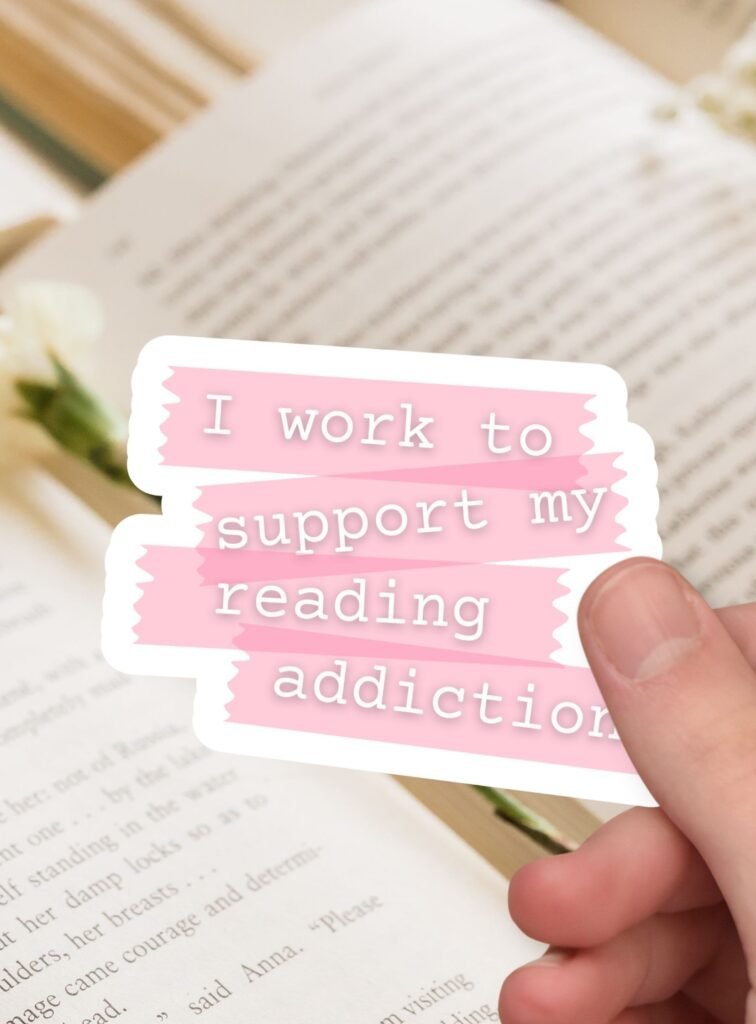 pink washi tape style sticker with I work to support my reading addiction text in white